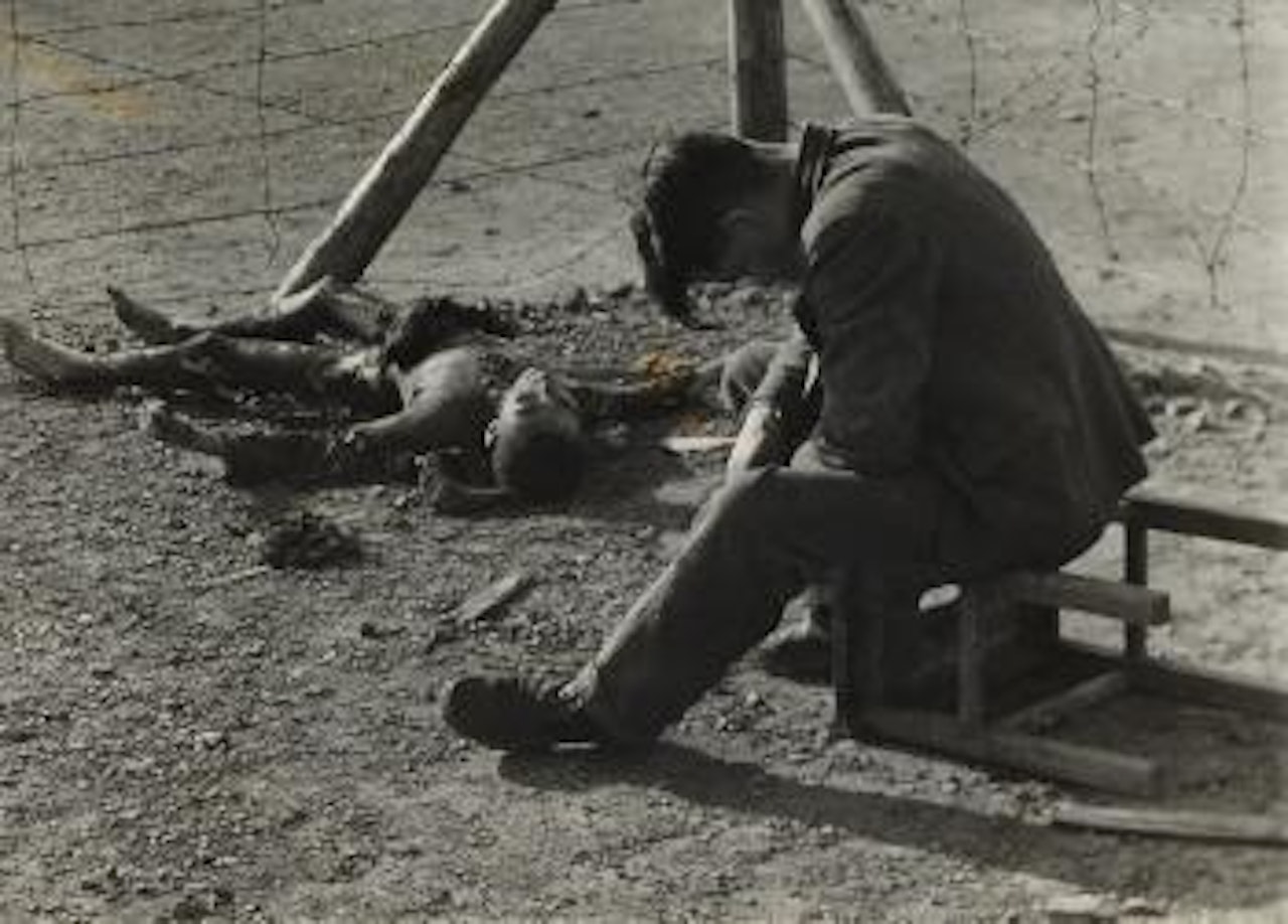 Erla Work Camp: A Pole sits bowed with grief over his Polish friend by Margaret Bourke-White