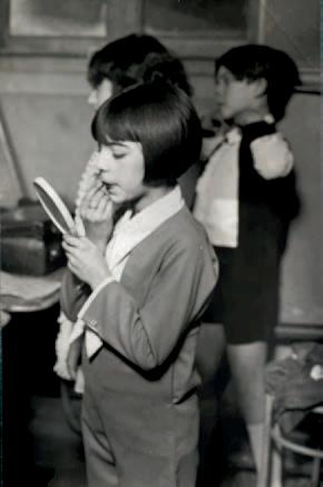 Petites filles se coiffant et se maquillant pour un spectacle by André Kertész