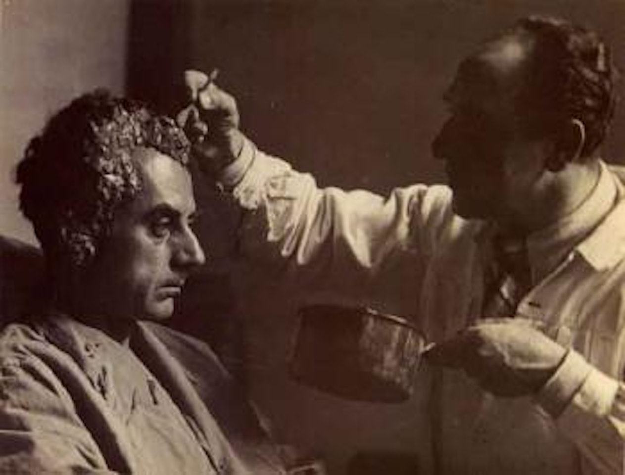 Paul Hamann making a life mask of Man Ray by Man Ray