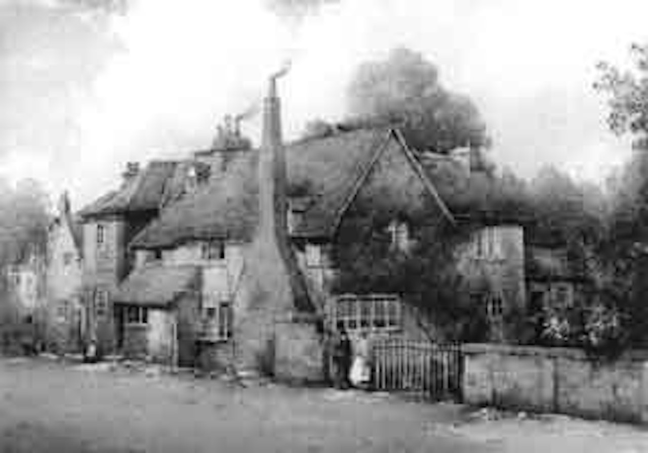 Chat by the garden wall, a village view by Noel Harry Leaver