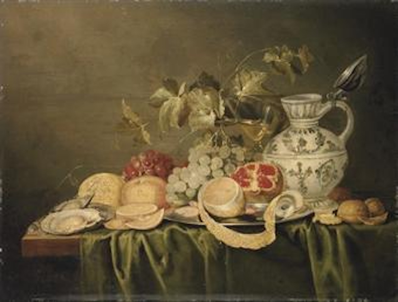 A sliced and peeled lemon with prawns on a silver platter, with oysters, oranges, grapes, a broken pomegranate, walnuts, a glass of wine and pitcher, on a partly-draped table by Jan Davidsz de Heem