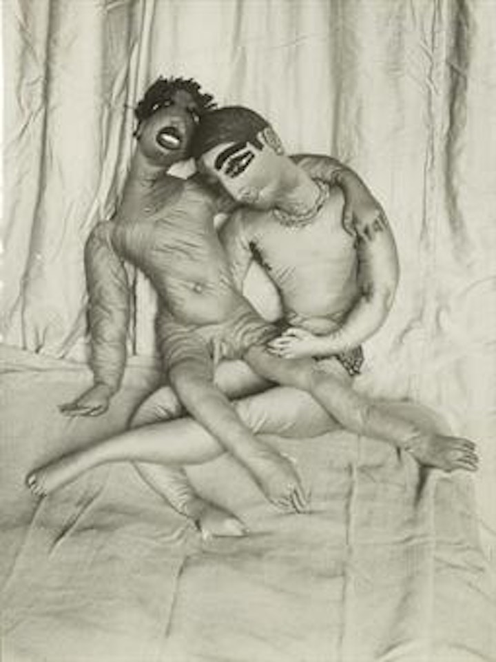 Two dolls on bed by André Kertész