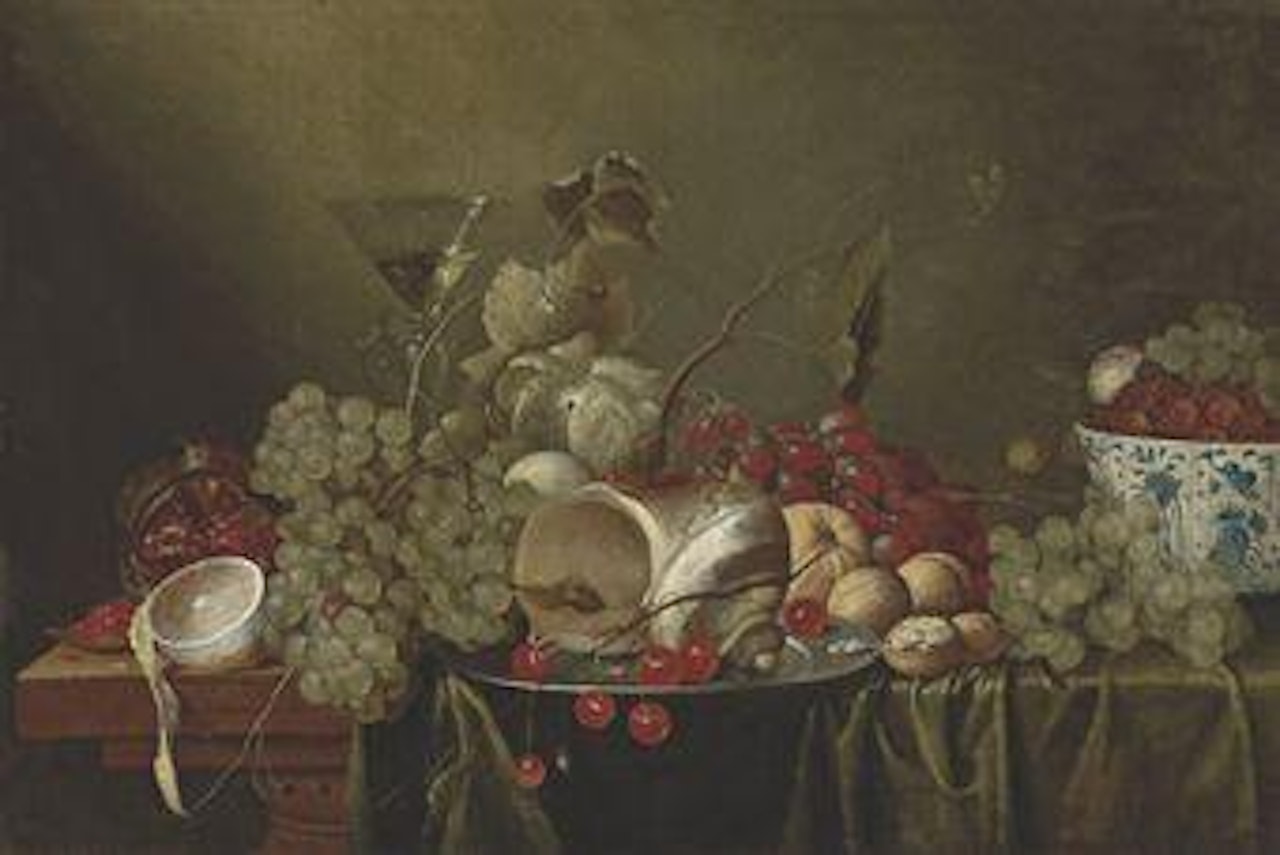 Cherries and a conch shell on a silver platter, a cut and peeled lemon, a pomegranate, grapes, a glass of wine, walnuts and berries in a kraak porcelain bowl, on a partly-draped wooden table by Jan Pauwel Gillemans