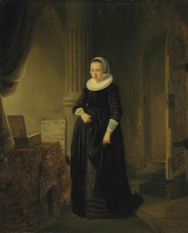 A young woman in an interior by Attributed to Rembrandt Harmensz van Rijn