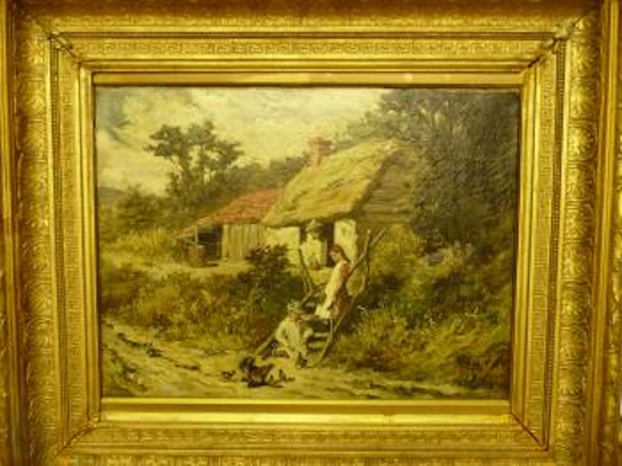 Two children feeding chickens beside a thatched cottage by John Emms
