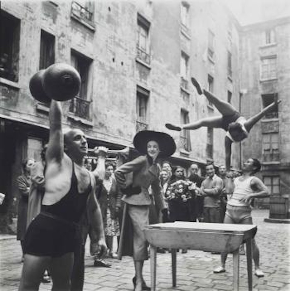 Elise Daniels with Street Performers, Suit by Balenciaga, Le Marais, Paris, August by Richard Avedon