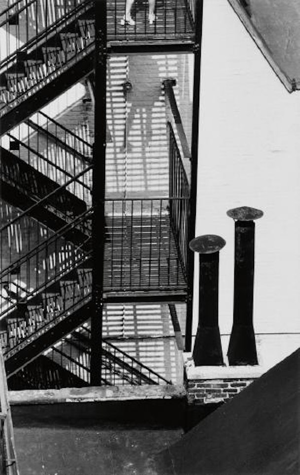 Fire escape, chimneys, and figure (MacDougal alley) by André Kertész