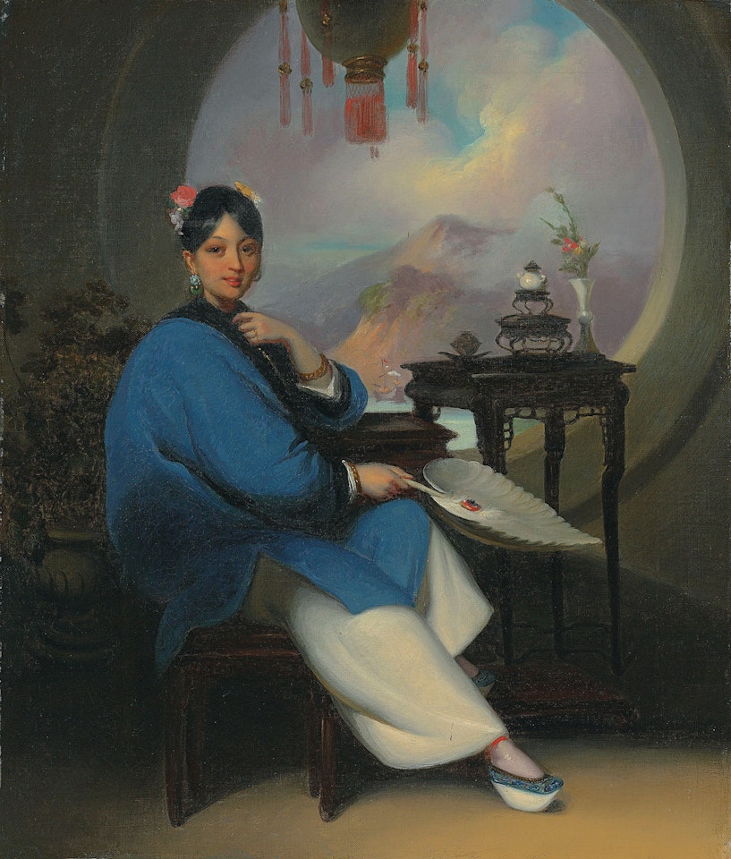 A Chinese woman seated, wearing flowers in her hair, jade earrings and blue nankeen dress, holding a feather fan, before a moon window, with a view to a Chinese coastal landscape beyond by George Chinnery