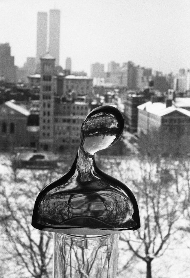 Figurine In Window With The World Trade Towers In The Background by André Kertész