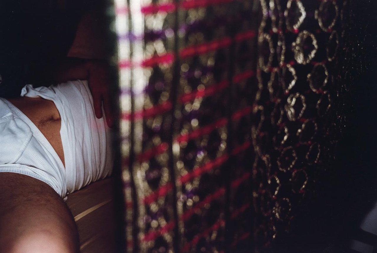 Clemens in my bed with saris, Paris by Nan Goldin