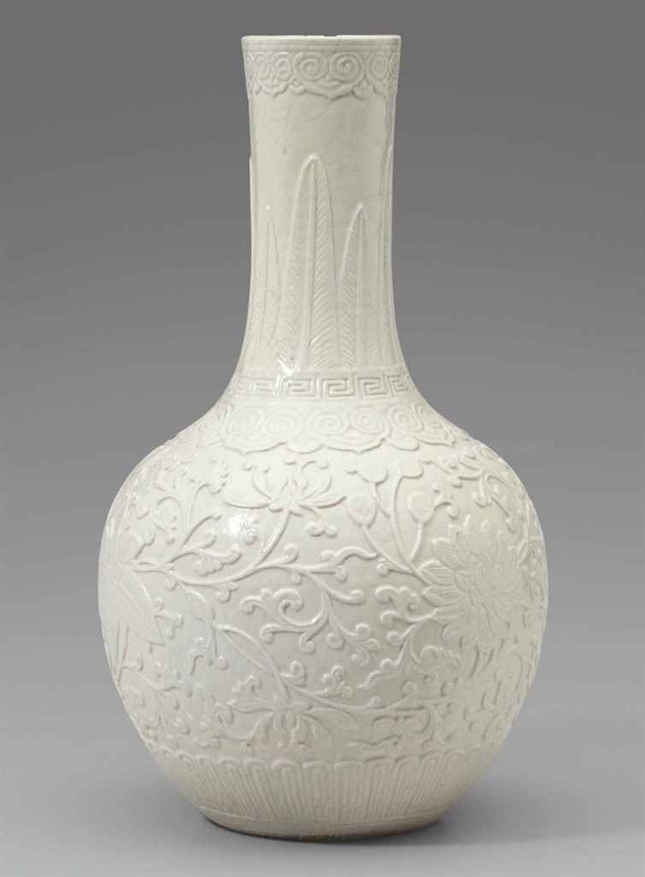 A MOLDED SOFT-PASTE CREAM-GLAZED VASE by Anonymous