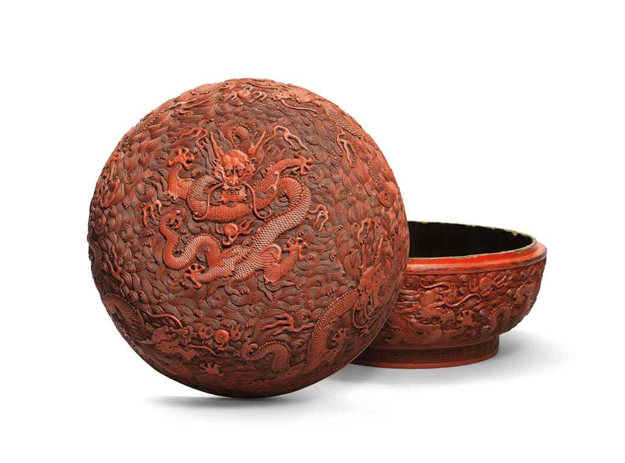 A CARVED CINNABAR LACQUER 'NINE DRAGONS' BOX AND COVER by Anonymous