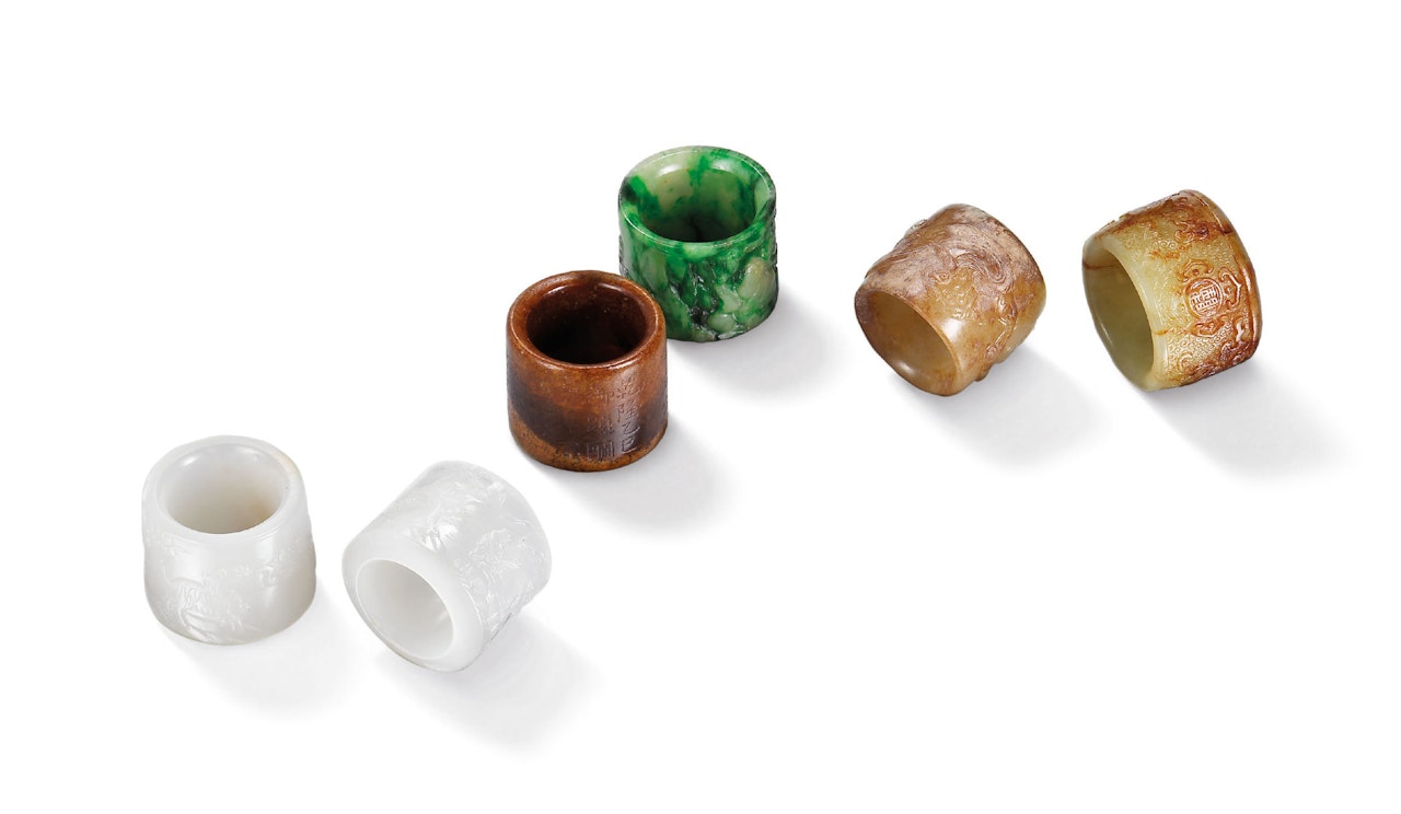A GROUP OF FIVE JADE AND ONE JADEITE ARCHER’S RINGS by Anonymous