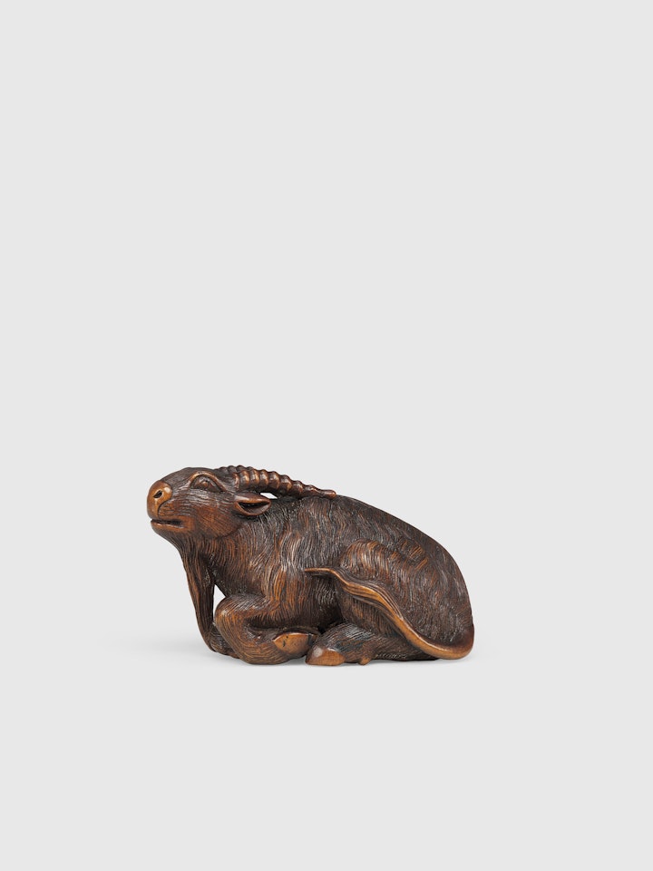 A WOOD NETSUKE OF A GOAT by Anonymous