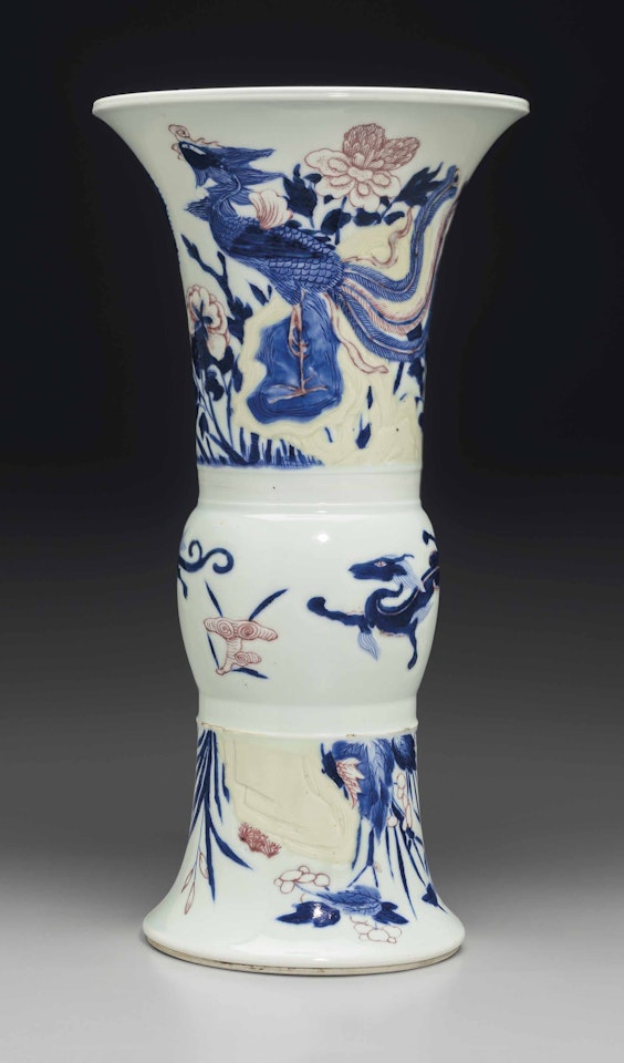 A COPPER-RED AND CELADON-DECORATED CARVED BLUE AND WHITE BEAKER VASE by Anonymous