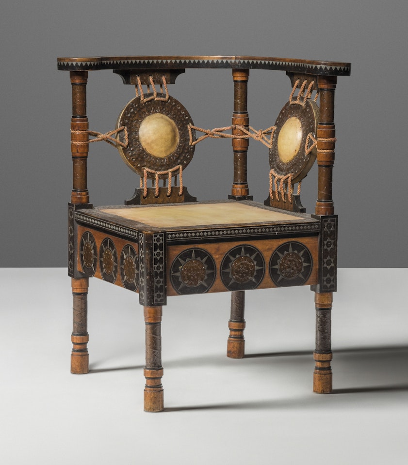 A CORNER CHAIR by Carlo Bugatti