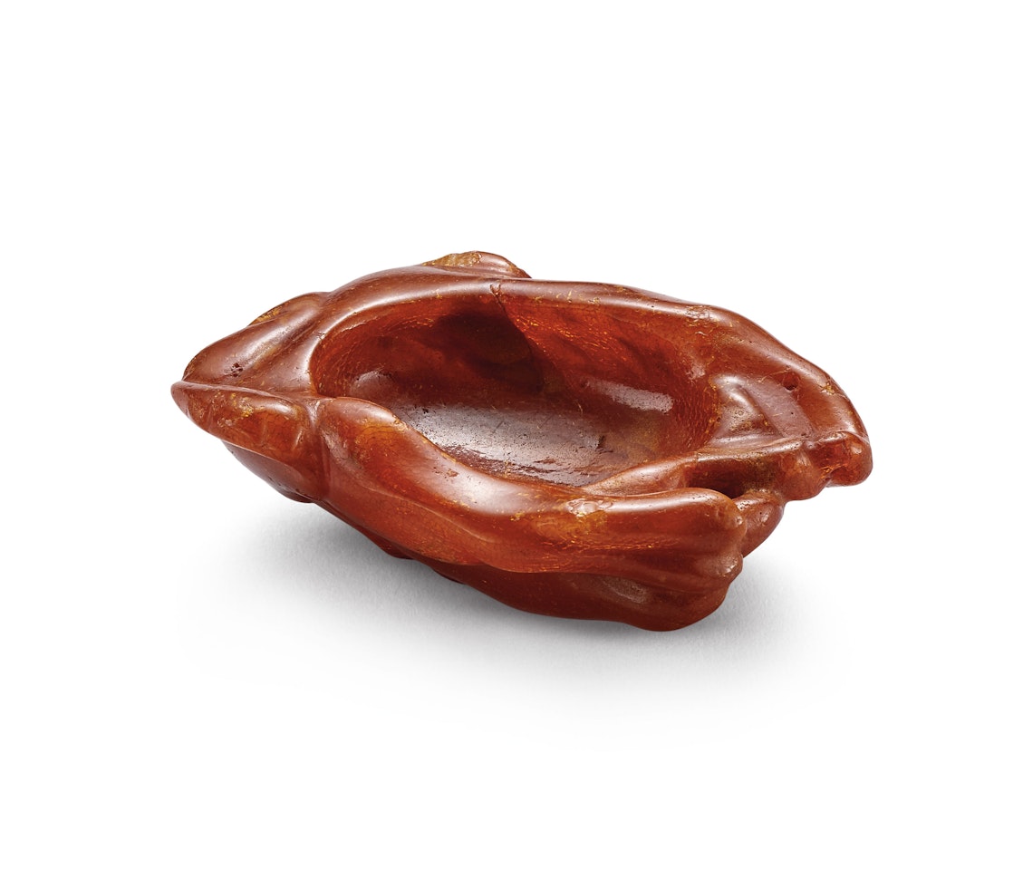 A CARVED AMBER FINGER CITRON-FORM WASHER by Anonymous
