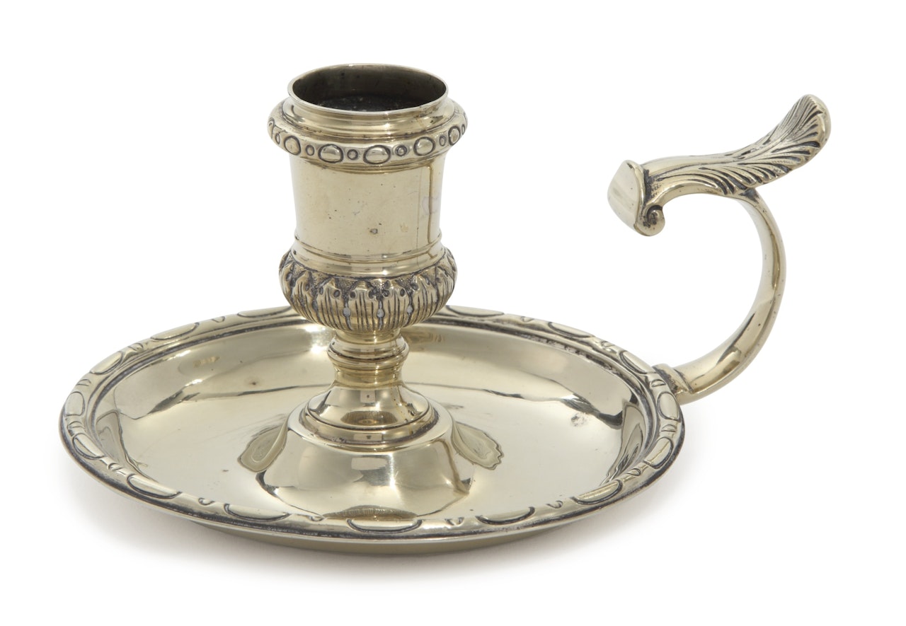 A silvered brass chamberstick by Anonymous