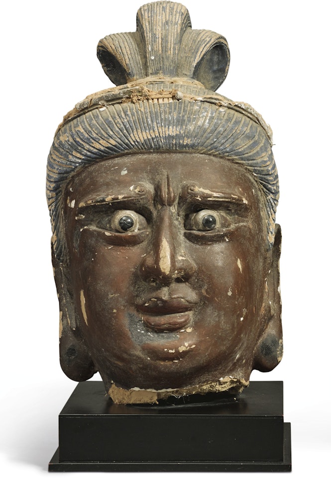 A LARGE STUCCO HEAD OF A GUARDIAN by Anonymous