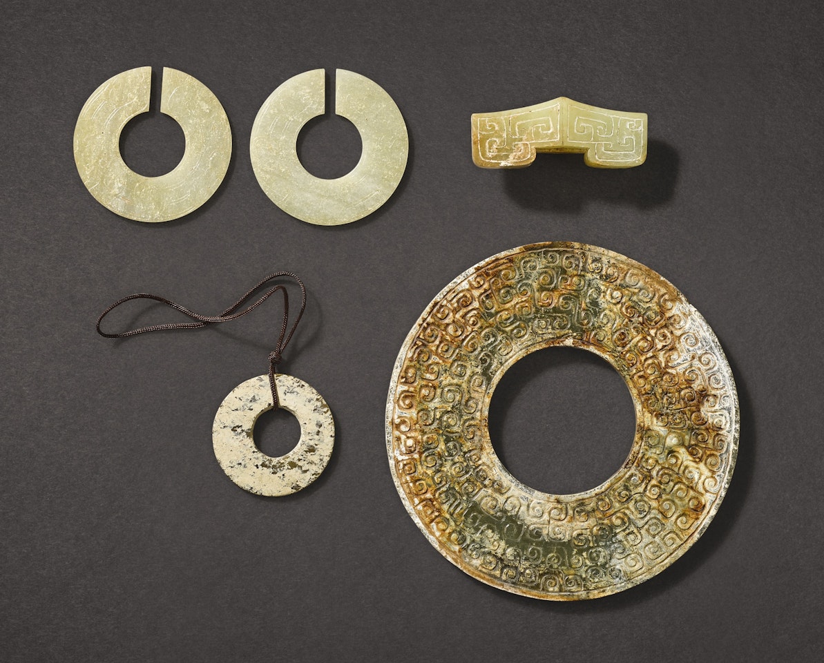 A CALCIFIED JADE DISC, HUAN, AND FOUR OTHER ARCHAISTIC JADE ITEMS by Anonymous