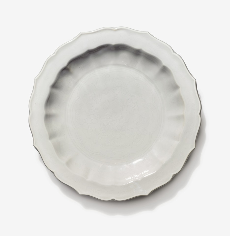 A SMALL INCISED TIANBAI-GLAZED BARBED DISH by Anonymous