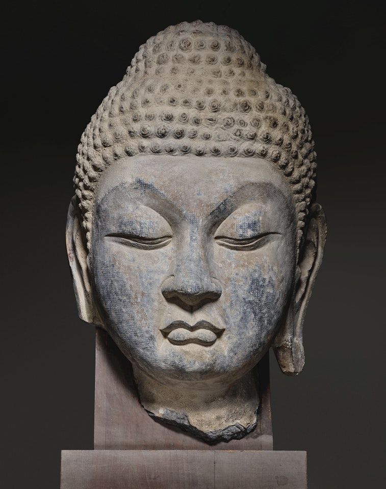 A SUPERBLY CARVED AND EXTREMELY LARGE LIMESTONE HEAD OF BUDDHA by Anonymous