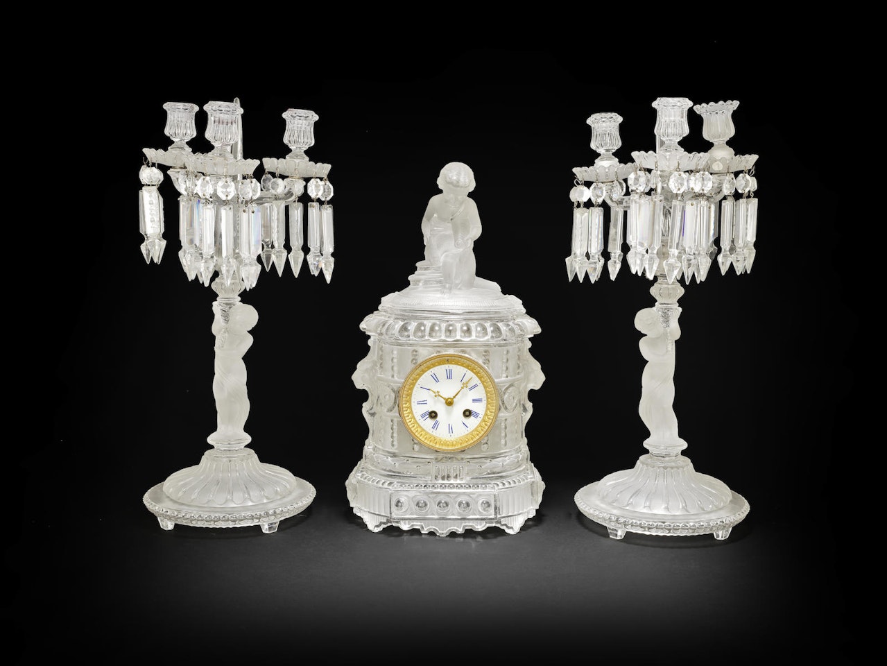 A Baccarat moulded and frosted glass clock garniture by Anonymous