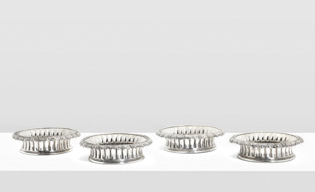 A set of four George IV silver wine bottle coasters by Rebecca Emes & Edward Barnard by Anonymous