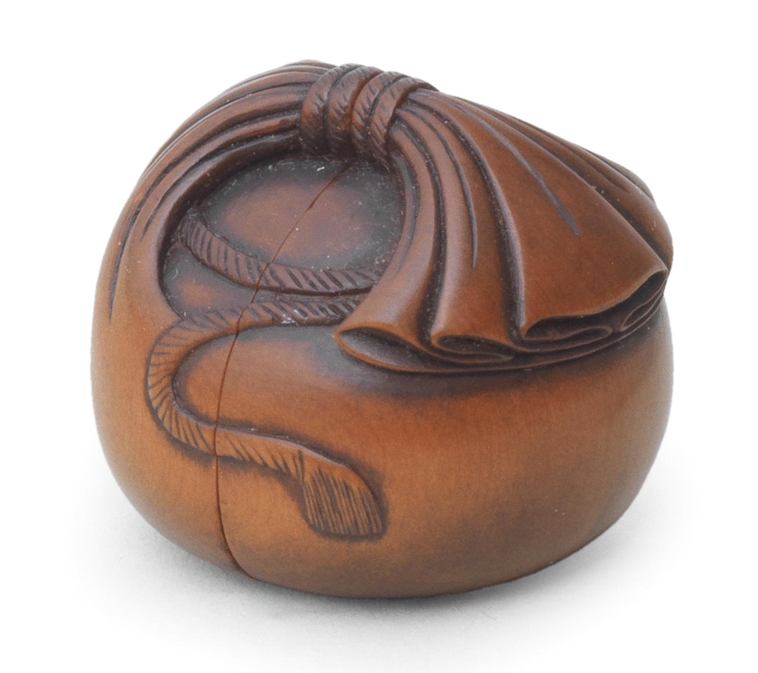 A boxwood netsuke of Hotei and two karako in a sack by Anonymous