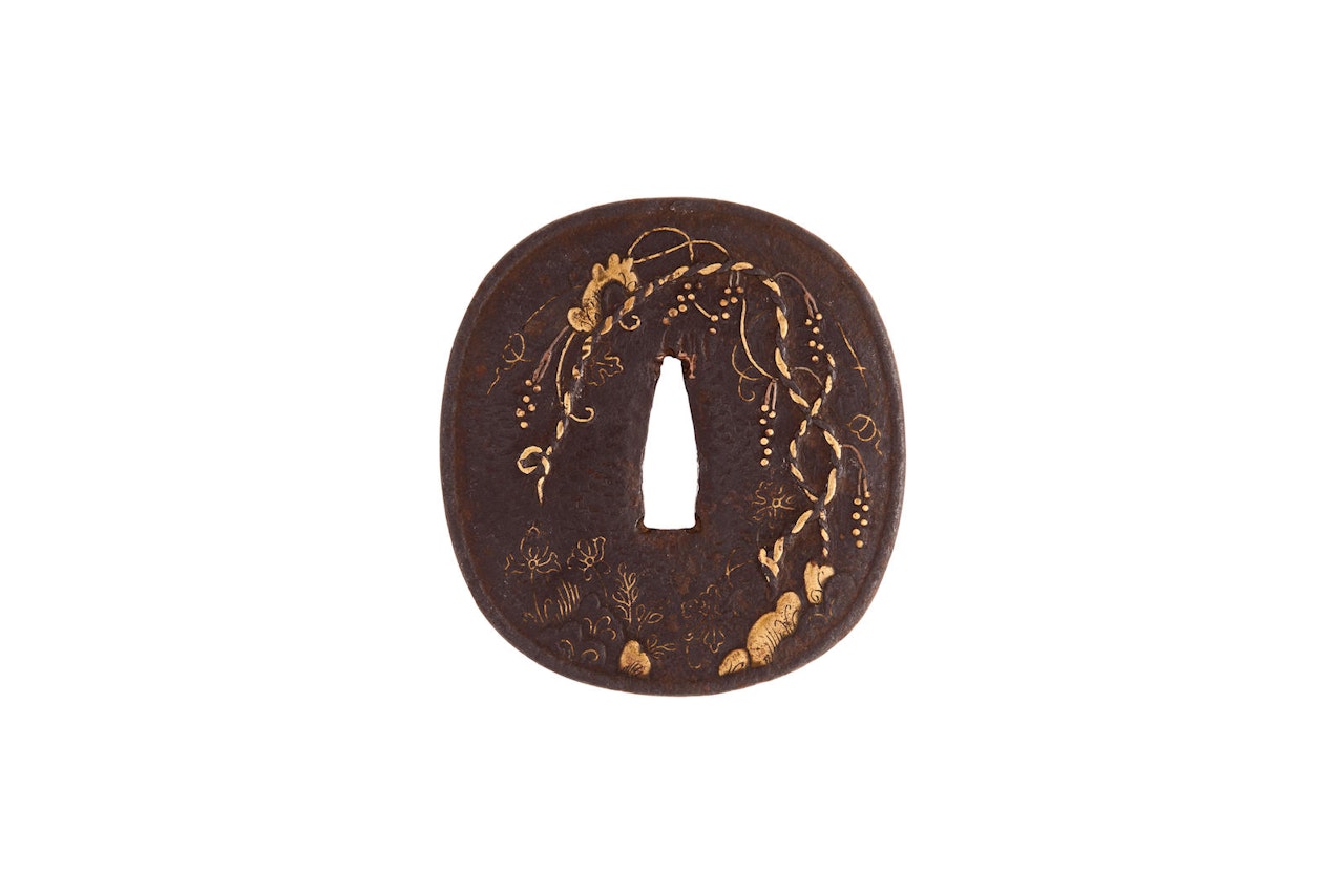 A brass-inlaid iron tsuba by Anonymous