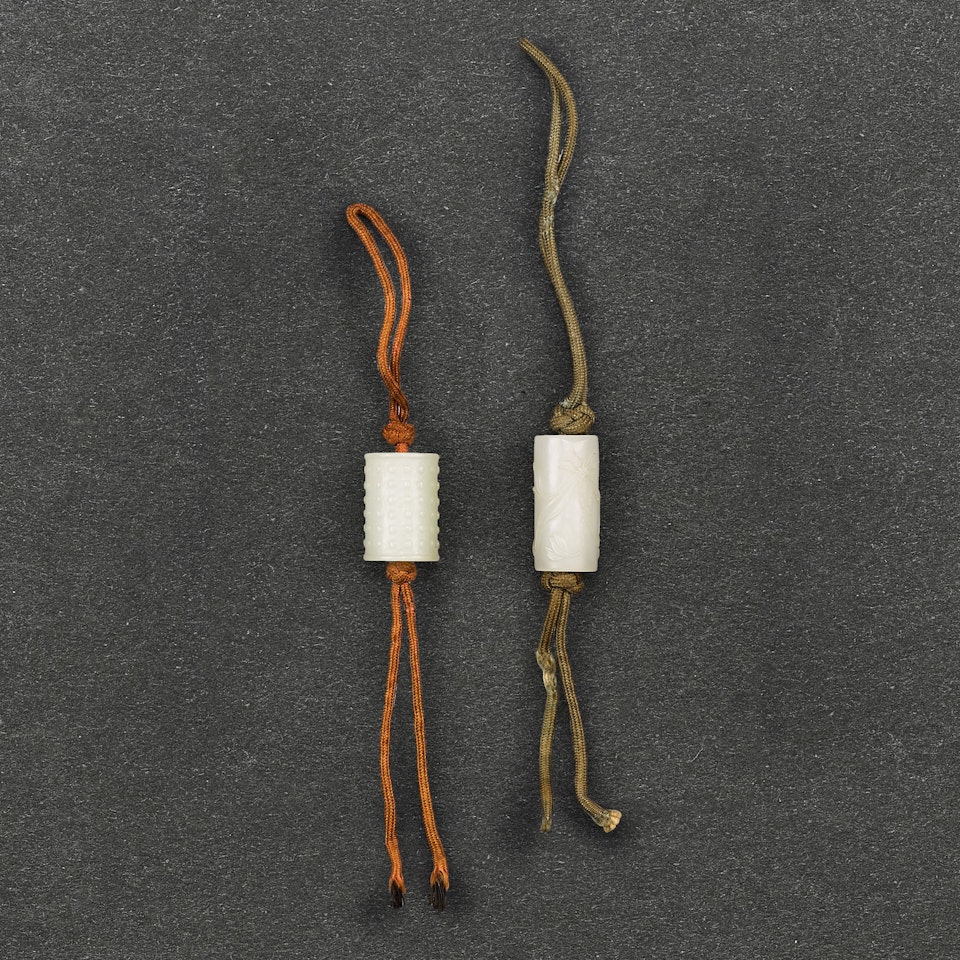 TWO WHITE JADE TUBULAR ‘BEAD’ PENDANTS by Anonymous