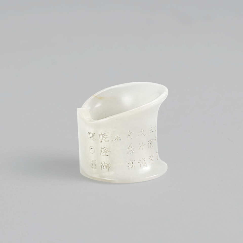 AN IMPERIALLY INSCRIBED WHITE JADE ARCHER’S RING by Anonymous