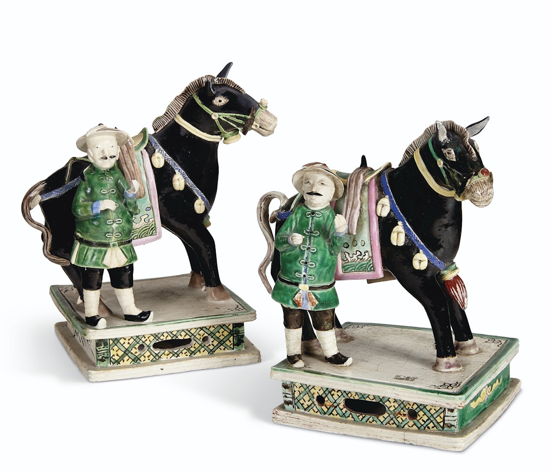 A PAIR OF BISCUIT-GLAZED ROSE-VERTE HORSES BESIDE RIDERS by Anonymous