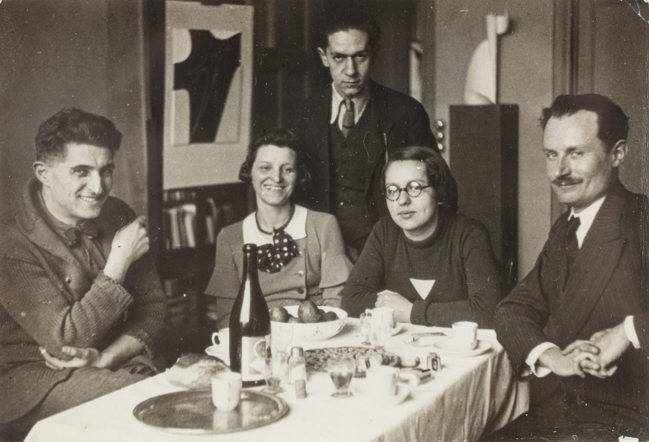 Etienne & Emma Béothy et des amis à table dans son studio à Montrouge, vers 1929 by André Kertész