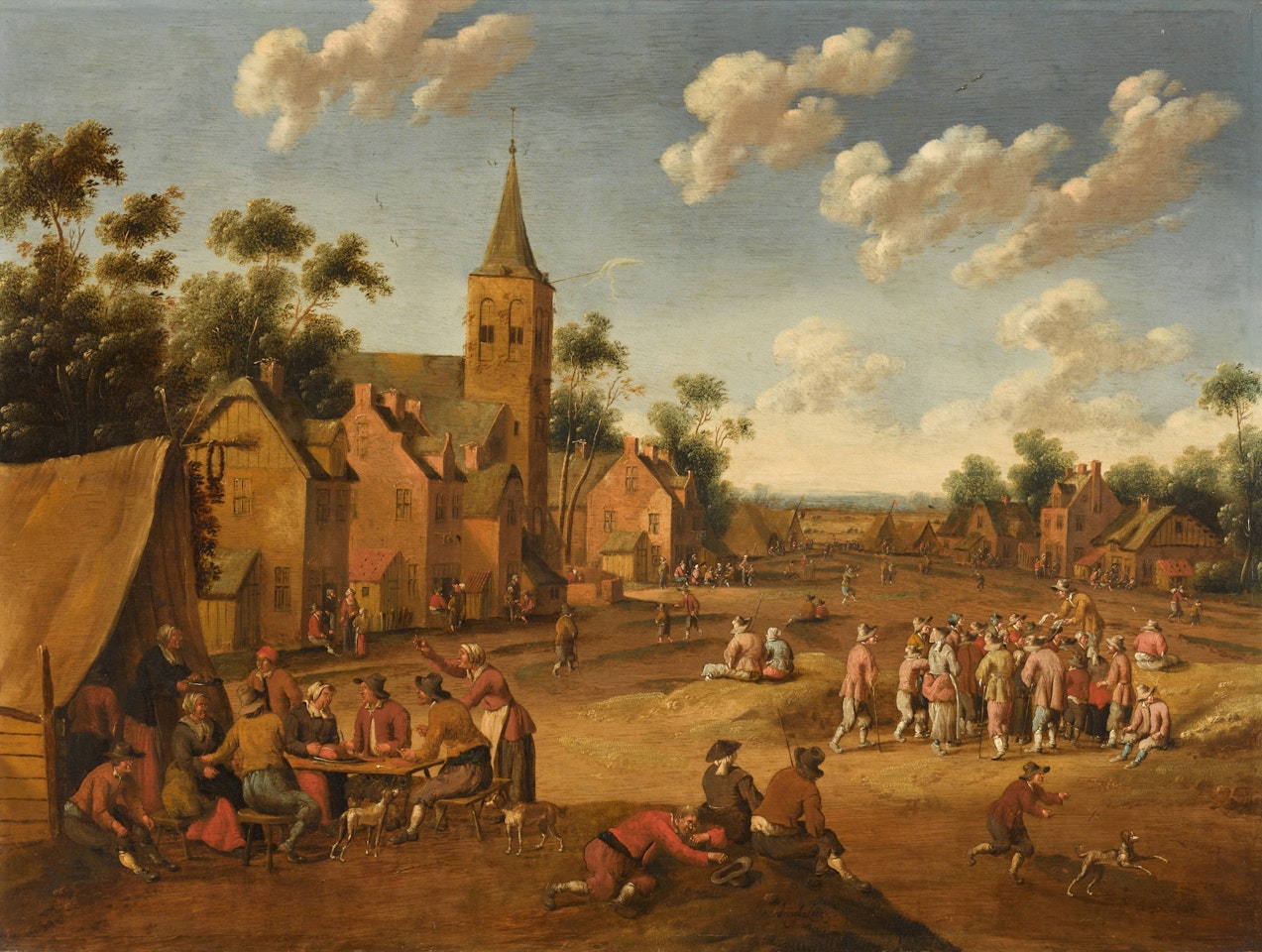 A village landscape with peasants at a table, gamblers in the middle distance, dogs and other figures with a church and houses beyond by Joost Cornelisz Droochsloot