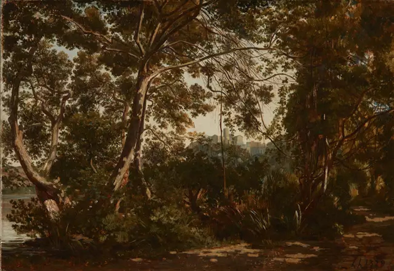 A forest landscape on the edges of a lake, a town beyond by Henri Harpignies