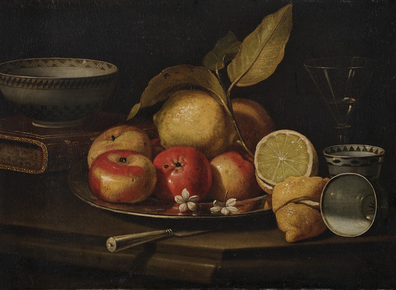 Nature morte aux plat de fruits, céramiques, livre et verre sur un entablement by Cristoforo Munari