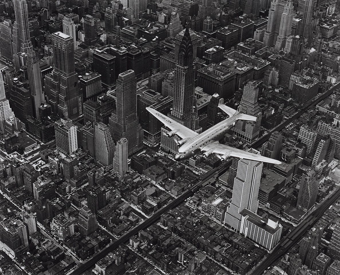A DC4 flying over New York City by Margaret Bourke-White