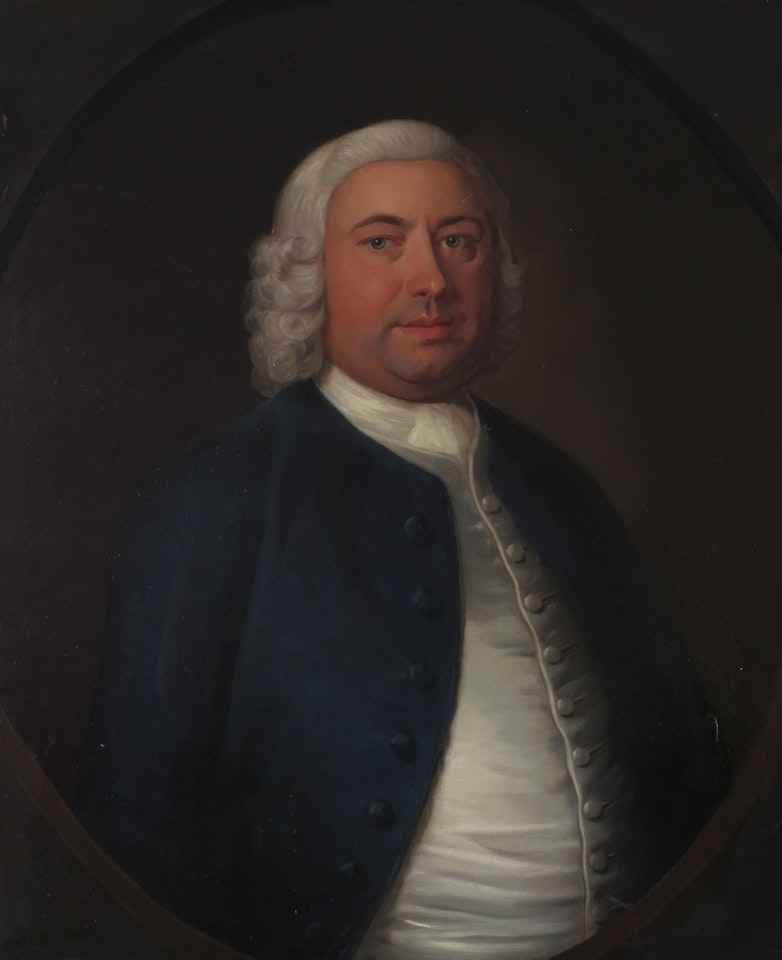 Portrait of a gentleman in a blue coat and white wig in a painted oval by English School