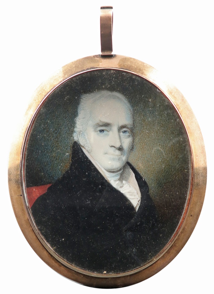 Portrait miniature of a gentleman, wearing a black coat and cream waistcoat, seated in a red chair by English School