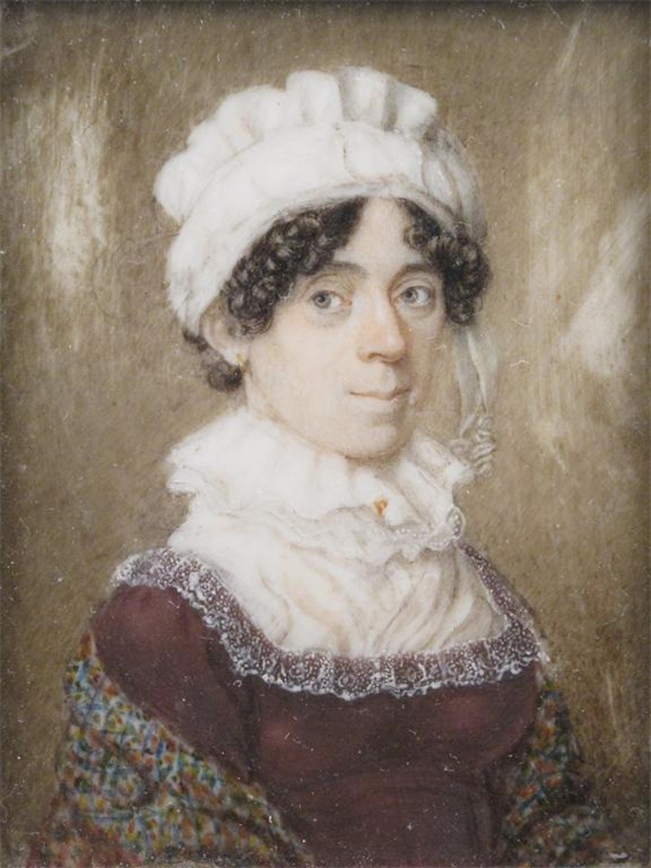 A lady, half length, facing right, wearing a red velvet dress over a lace blouse with a high collar a white bonnet and a coloured shawl by English School