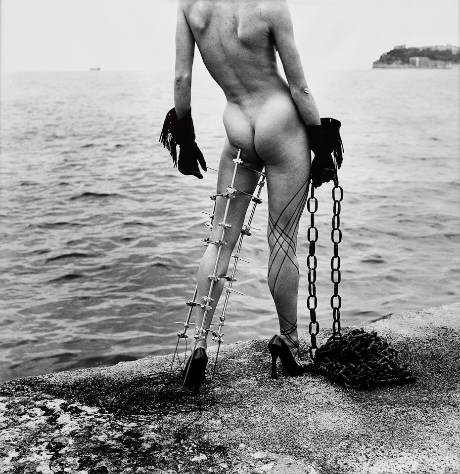 Nude in Black Gloves with Metal Leg Support by the Sea, Monte-Carlo by Helmut Newton