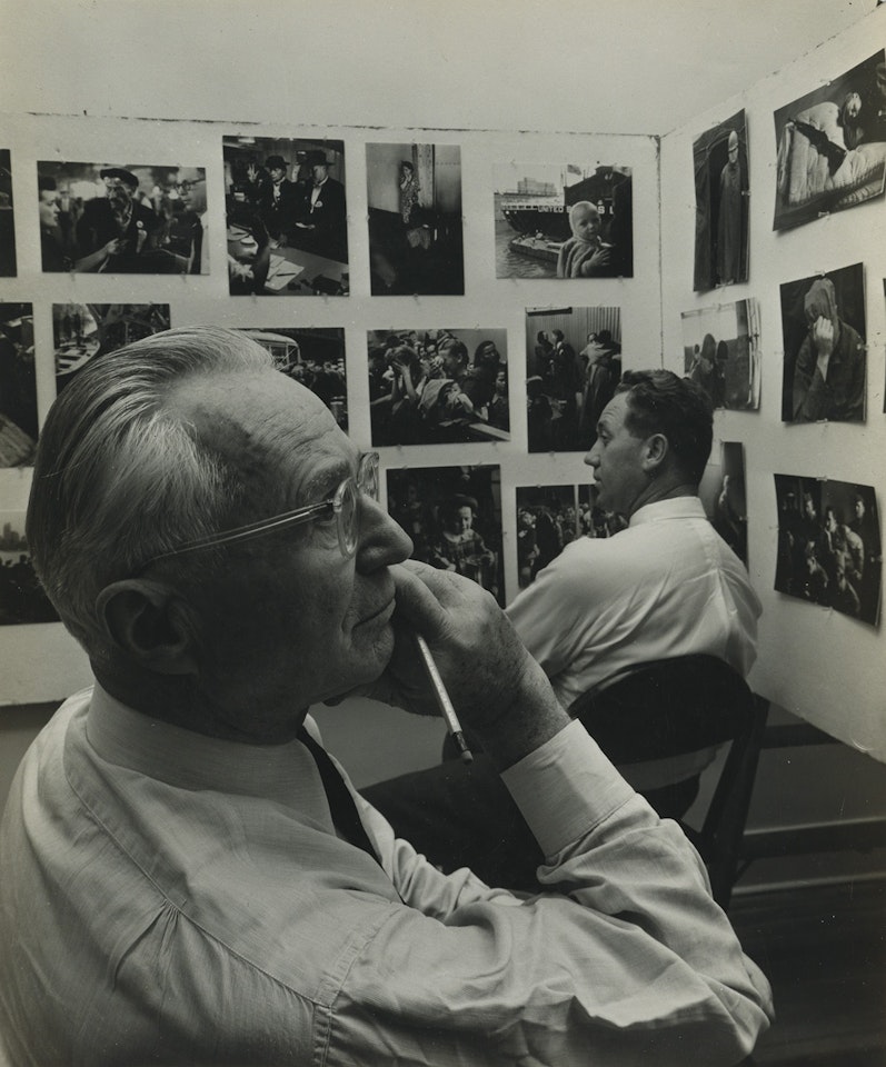 Edward Steichen making selections for the The Family of Man publication at the Museum of Modern Art, New York. by Arnold Newman