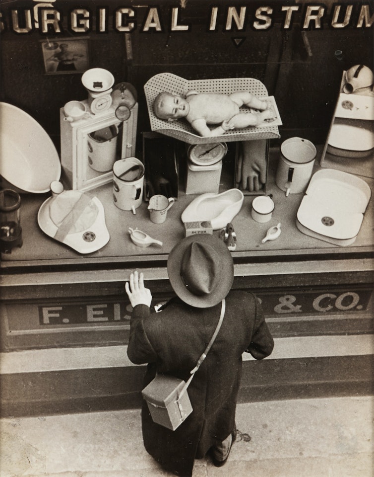 Untitled (man gazing in shop window) by André Kertész